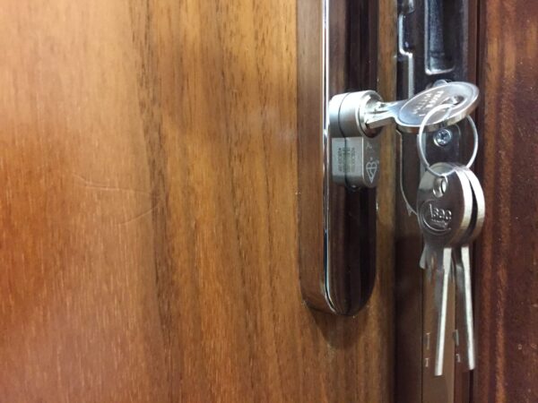 Euro cylinder lock change between tenancies Belfast - new keys in freshly fitted lock on wooden door